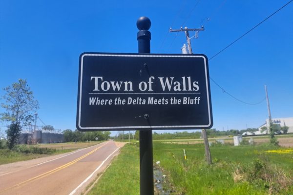 Town of Walls, MS sign with a rural landscape and open roads, highlighting the area's natural beauty. Expert lawn care services available in Walls and surrounding Mid-South communities.