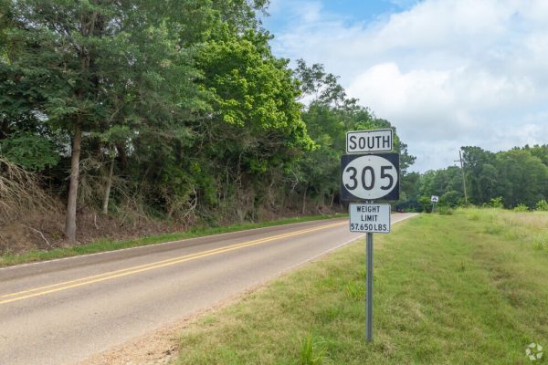 Scenic rural road along Highway 305 in Lewisburg, MS, featuring lush greenery and open landscapes. Expert lawn care services available in Lewisburg and surrounding Mid-South areas.