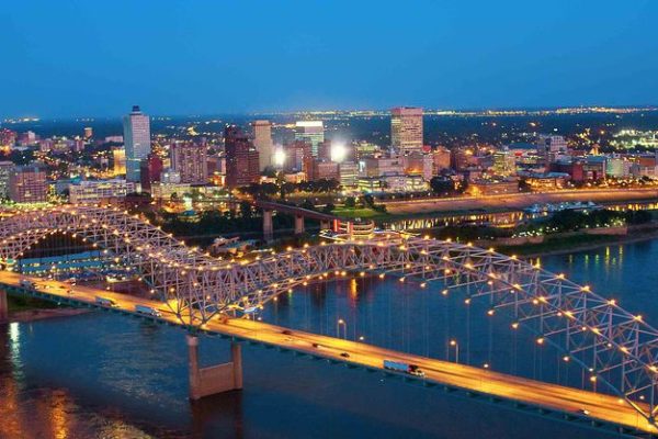 Stunning night view of the Memphis, TN skyline featuring the illuminated Hernando de Soto Bridge over the Mississippi River. Professional lawn care services available in Memphis and surrounding Mid-South areas.